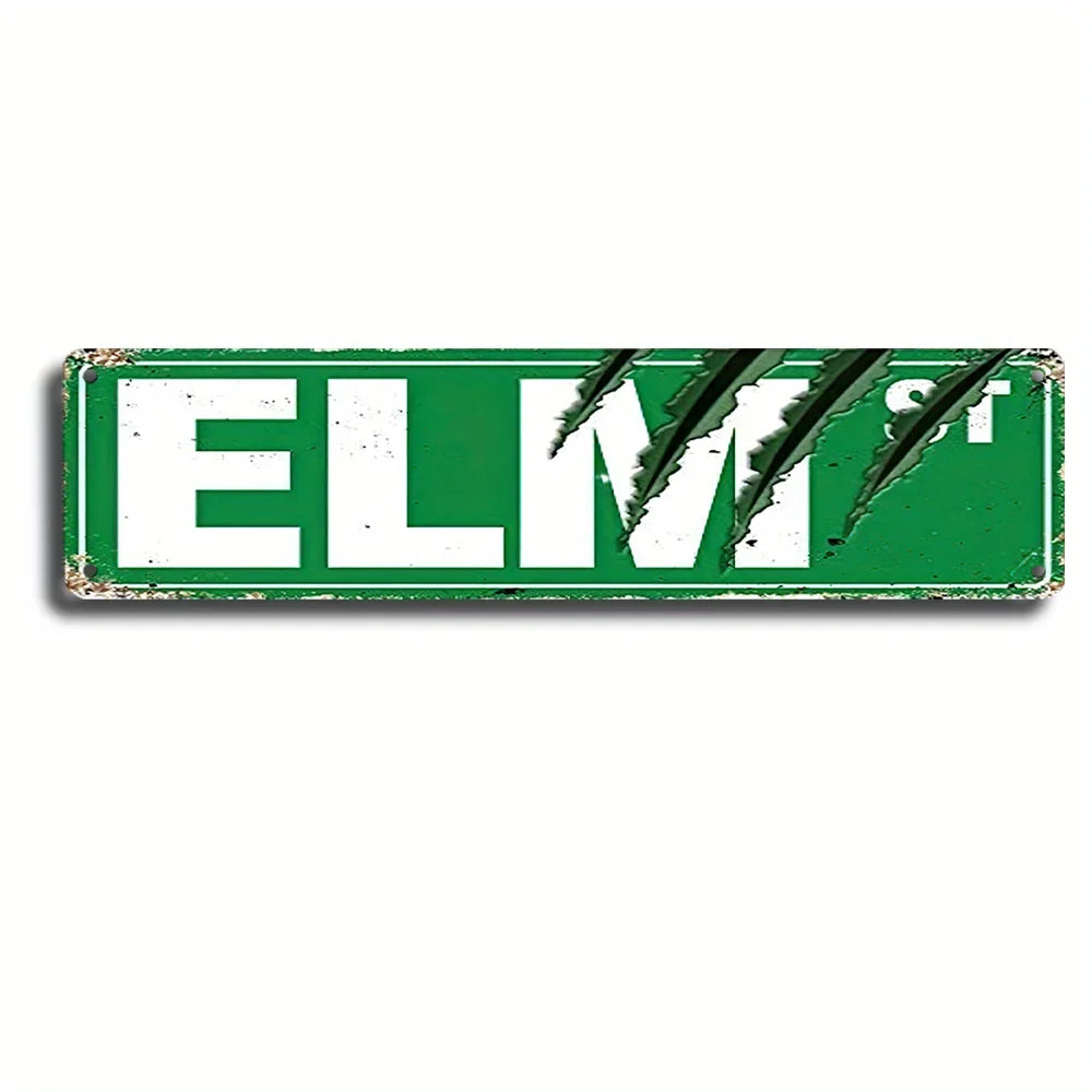 A vintage metal wall sign with the text ELM St in white on a green background.