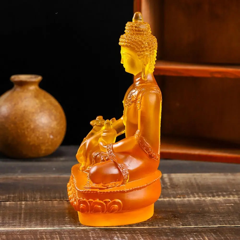 Handcrafted resin Medicine Buddha statue in orange-yellow color sitting in meditation pose