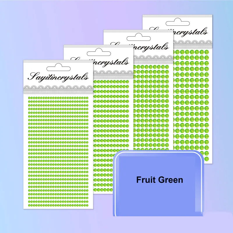 A stack of clear packaging for colorful self-adhesive rhinestone embellishments in various shades of green.
