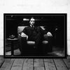 Black and white portrait of a man in a suit sitting in an armchair, resembling a classic movie poster.