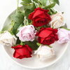 A bouquet of realistic red and pink velvet artificial roses on a white plate.