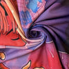 A close-up of a purple and red decorative tapestry fabric draped and folded.