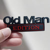 A hand holds a black and red door emblem with the text Old Man Edition.