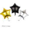 Un ensemble de trois ballons en feuille or, noir et argent, en forme d'étoiles.