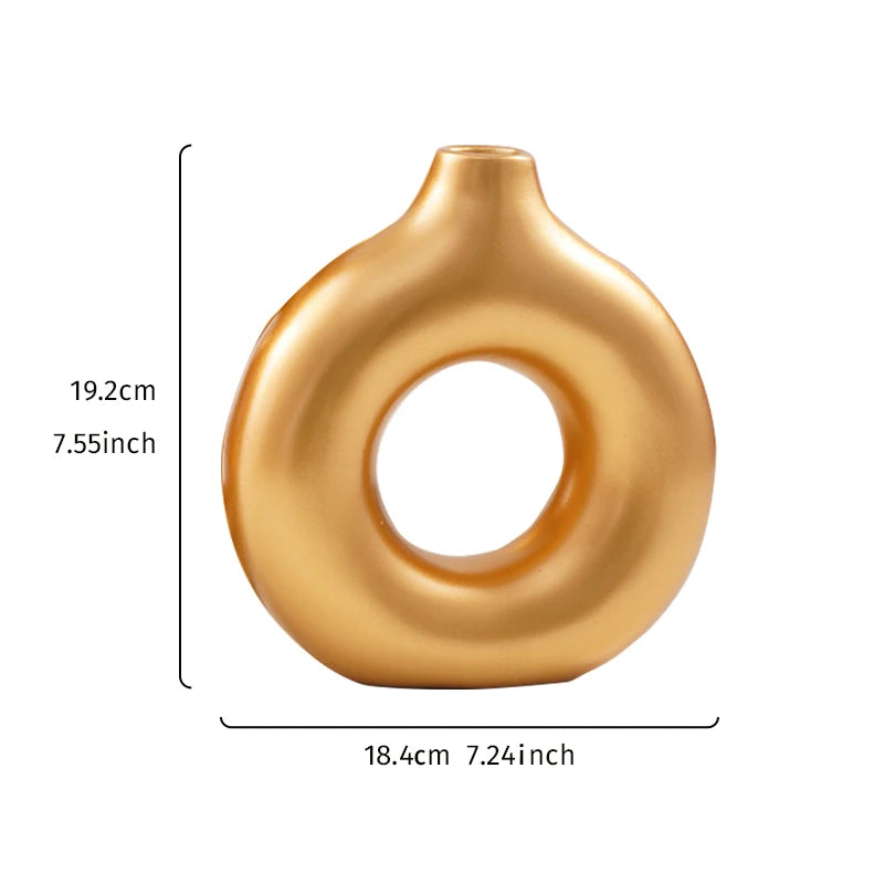 A smooth, golden, ring-shaped resin vase with a flared opening.