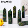 A collection of dark green emerald crystal point healing wands displayed on a white surface.