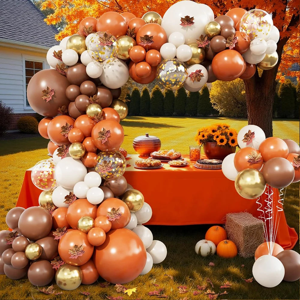 A large arrangement of orange, gold, and white latex balloons decorated for a party or wedding.