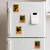 A white refrigerator decorated with several framed wooden magnets featuring artwork of a black cat eating food.