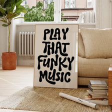 A framed black text art poster on a white background that reads PLAY THAT FUNKY MUSIC, displayed indoors.