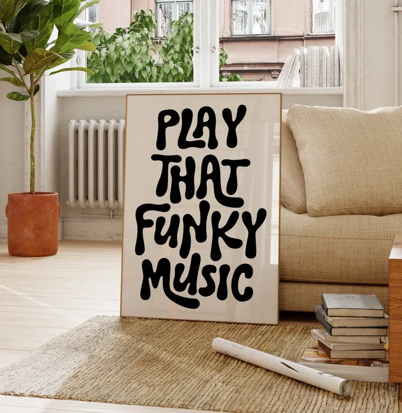 A framed black text art poster on a white background that reads PLAY THAT FUNKY MUSIC, displayed indoors.