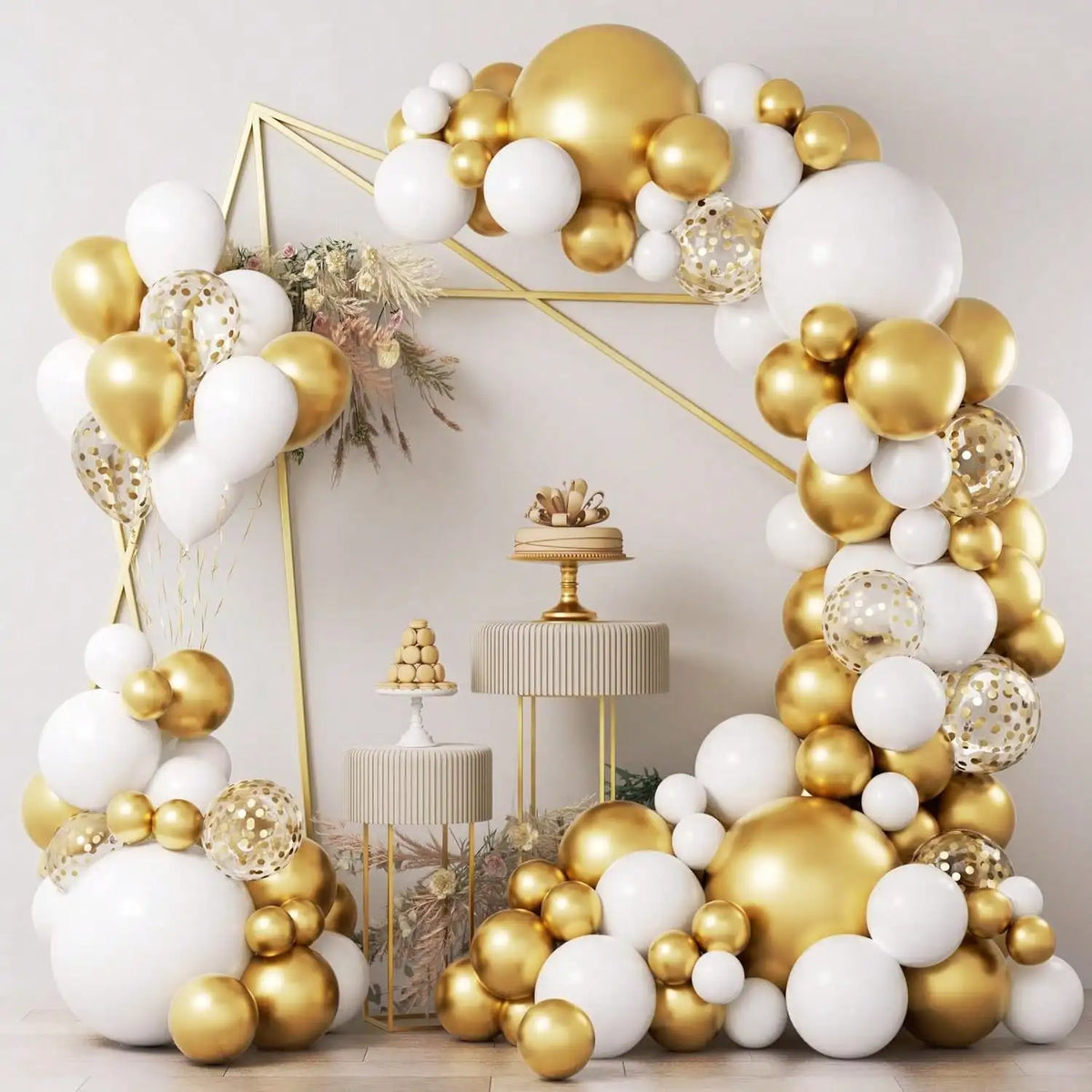 A balloon garland featuring white and gold latex balloons with confetti accents arranged in an arch shape.