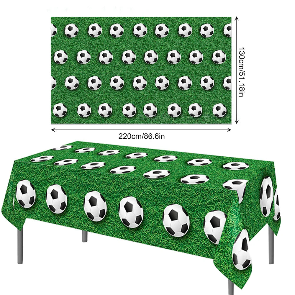 A green soccer field display featuring numerous black and white soccer balls arranged in rows.