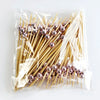 A clear plastic bag filled with pearl-tipped bamboo cocktail picks featuring a rose gold finish.