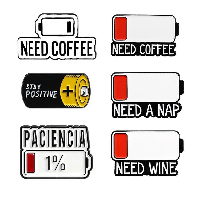 A set of enamel pins featuring various phrases like Need Coffee, Stay Positive, Paciencia, and Need Wine.