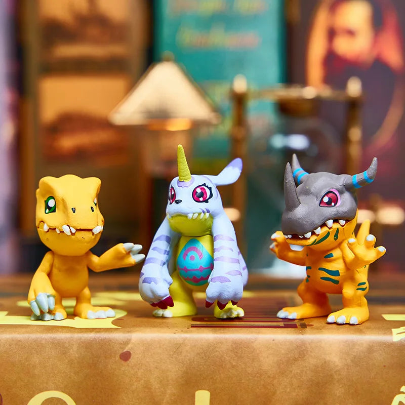 Three Digimon Adventure figures, including Tyrannosaurus and Triceratops, displayed on a surface.