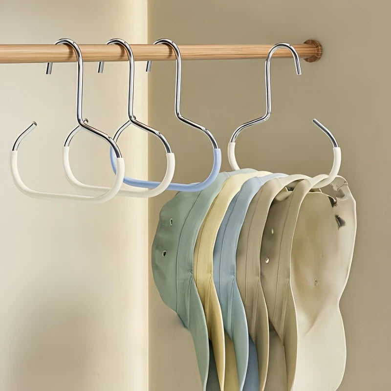 A set of metal hat storage hooks hanging on a wooden rack, with various colored hats displayed below.