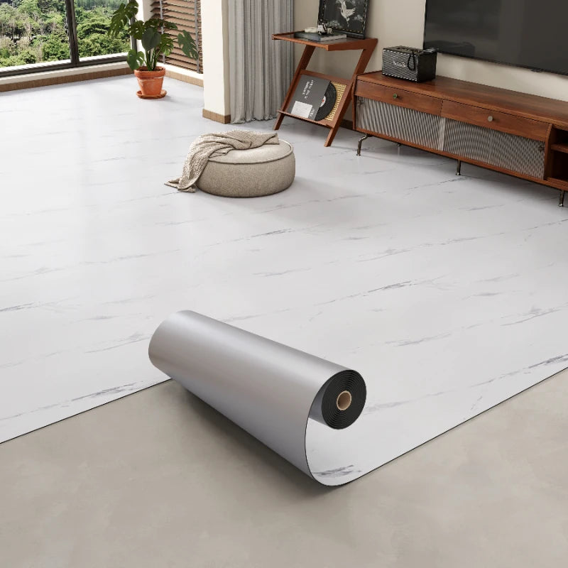 Roll of 3D textured wood grain self-adhesive flooring film displayed on a light floor.