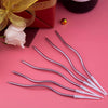 A set of silver spiral birthday cake candles with white tips and gold star toppers on a pink background.