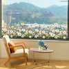 A bright interior view showing a window with a field of white daisy flower decals outside.