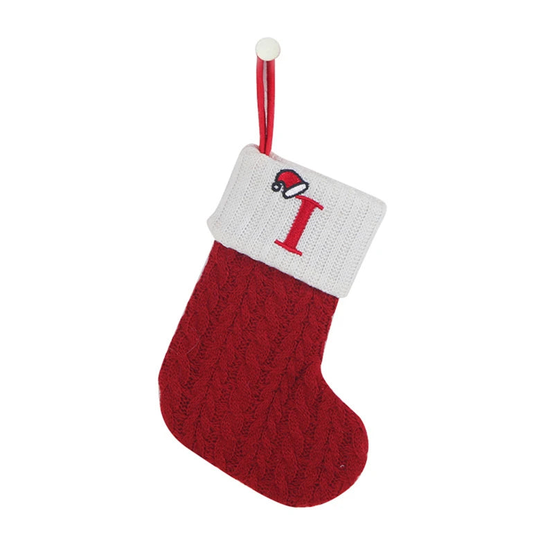 A red knitted sock with a white alphabet letter I on the toe and a hanging loop for tree decoration.