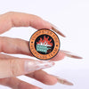 An enamel pin featuring a stylized fire and dumpster design for the Dumpster Fire Response Team.