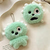 A pair of light green fuzzy plush toys shaped like monsters or creatures, used as keychains with clear photo card holders.