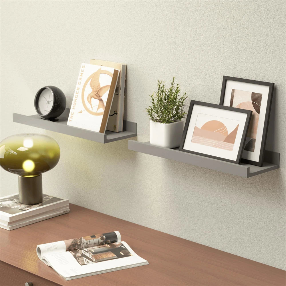 A rustic floating wood shelf set featuring framed art and a clock on a light gray wall.