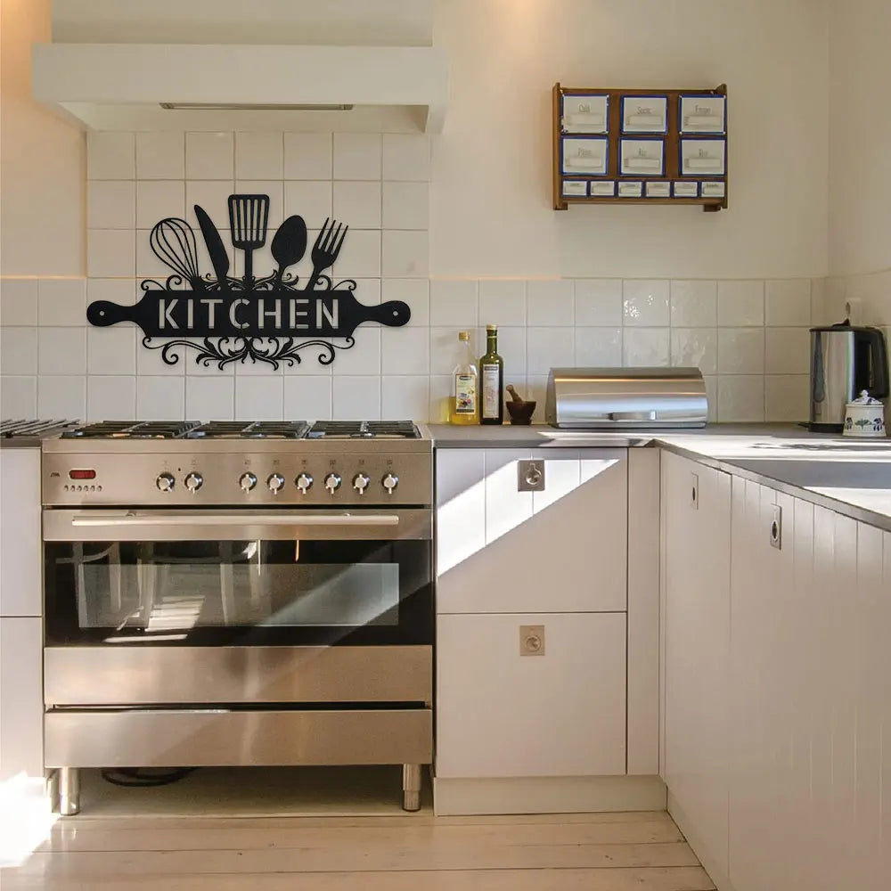 A rustic farmhouse metal wall sign featuring silhouette utensils mounted above a stainless steel oven in a kitchen.