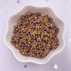 A small white dish filled with brown resin flower gems with yellow centers for crafts and DIY projects