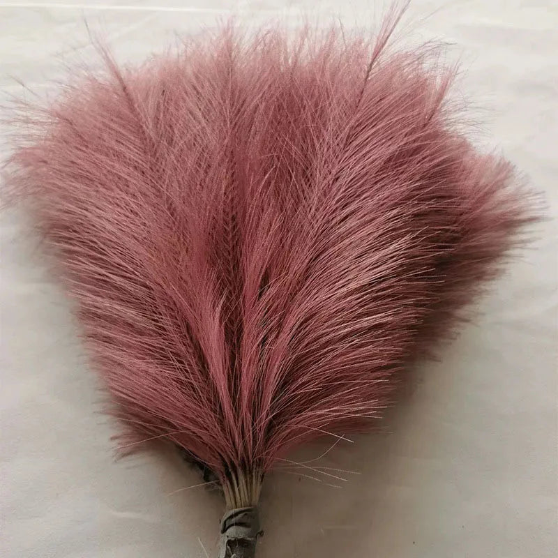 A fluffy pink artificial pampas grass stem used for boho wedding and home decor.