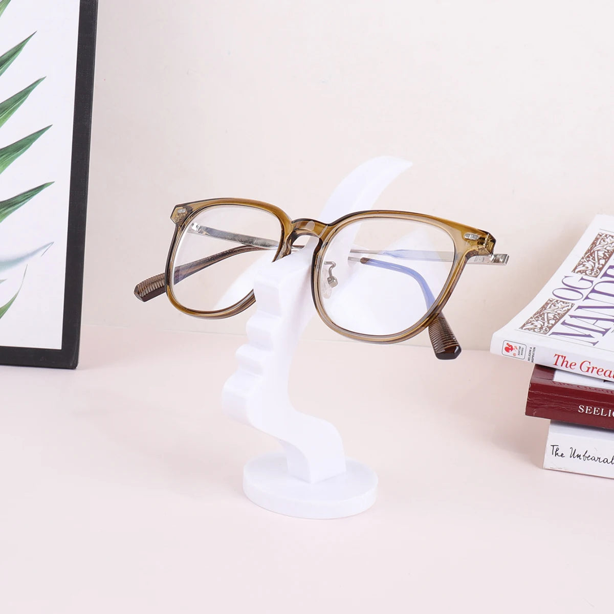 A pair of round, gold-rimmed glasses resting on a white minimalist display stand.