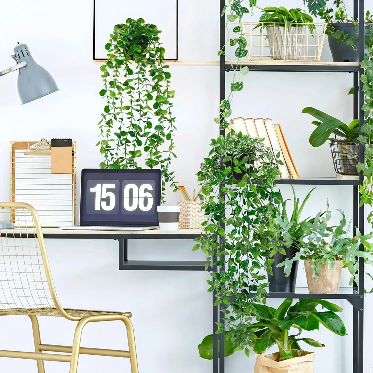 A vertical display of artificial eucalyptus hanging plants and greenery on a black shelf system.