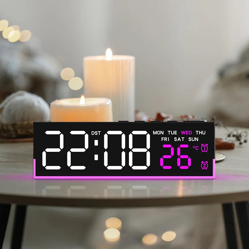 A digital LED alarm clock displaying 22:08 and 26 degrees on a dark panel with purple lighting, set on a wooden table.