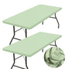 A light green stretch elastic tablecloth cover draped over a black metal table.