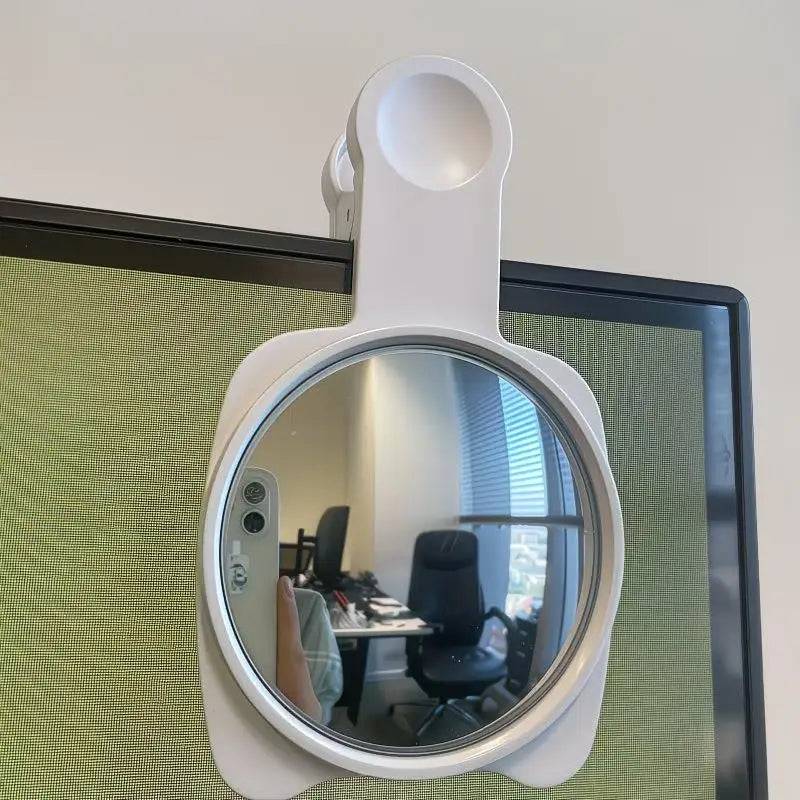 A white 360° adjustable privacy convex mirror mounted on a desk for viewing.