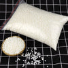 A white bag of natural soy wax flakes is shown next to loose flakes on a black grid background.
