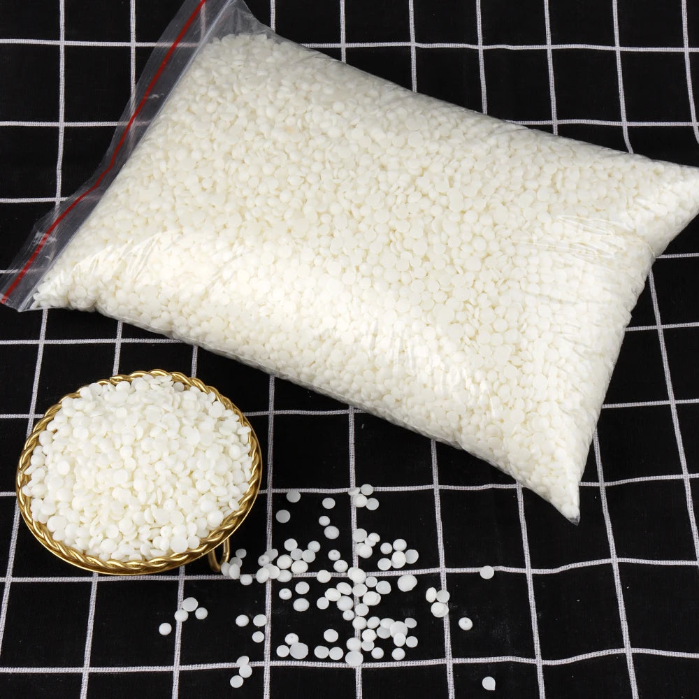 A white bag of natural soy wax flakes is shown next to loose flakes on a black grid background.