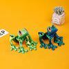 A bright green articulated 3D printed frog magnet with large eyes is displayed next to a small succulent plant.