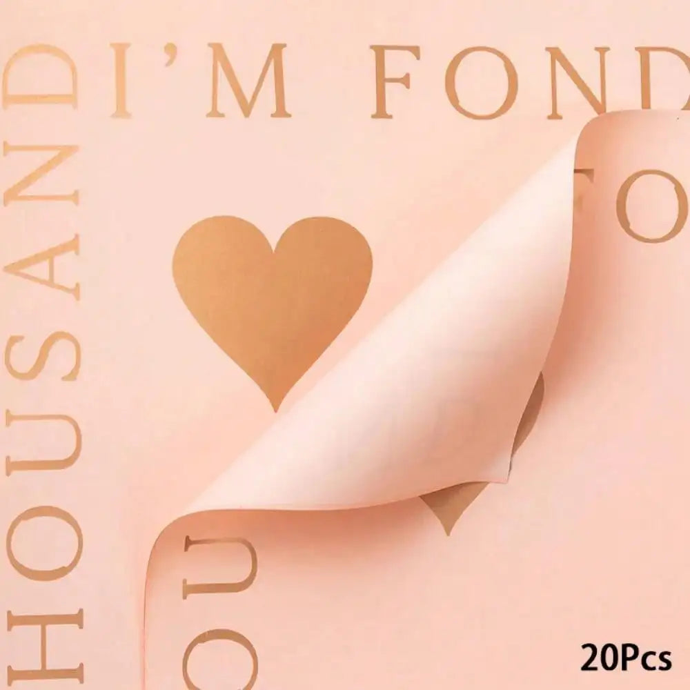 A sheet of peach-colored wrapping paper with gold text and a heart cutout, showing the texture and design.