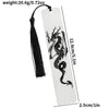 A white tag with a black dragon design is attached to a tassel, used as an elegant reading accessory.