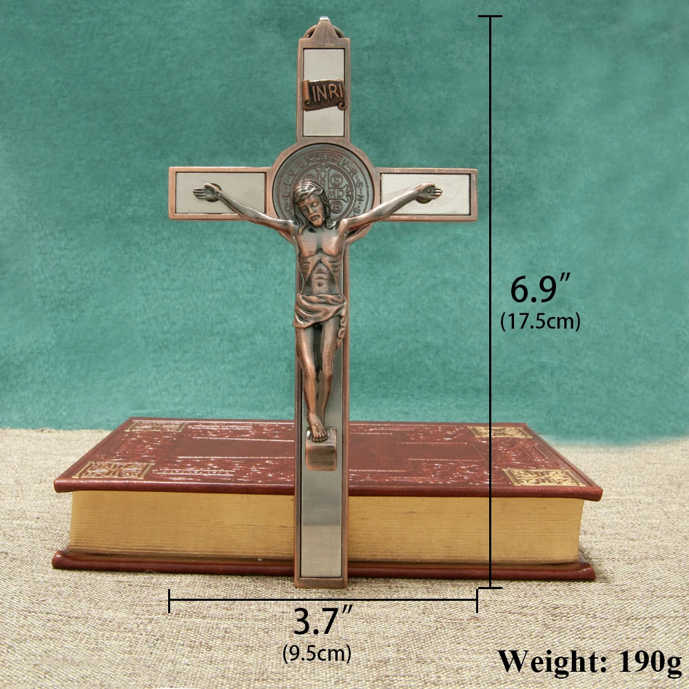 A bronze crucifix featuring a figure of Christ with a St. Benedict medal and INRI inscribed on the cross, displayed above a r