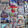 A collection of wooden fridge magnets featuring various destinations like Copenhagen, Hong Kong, and Malaysia.
