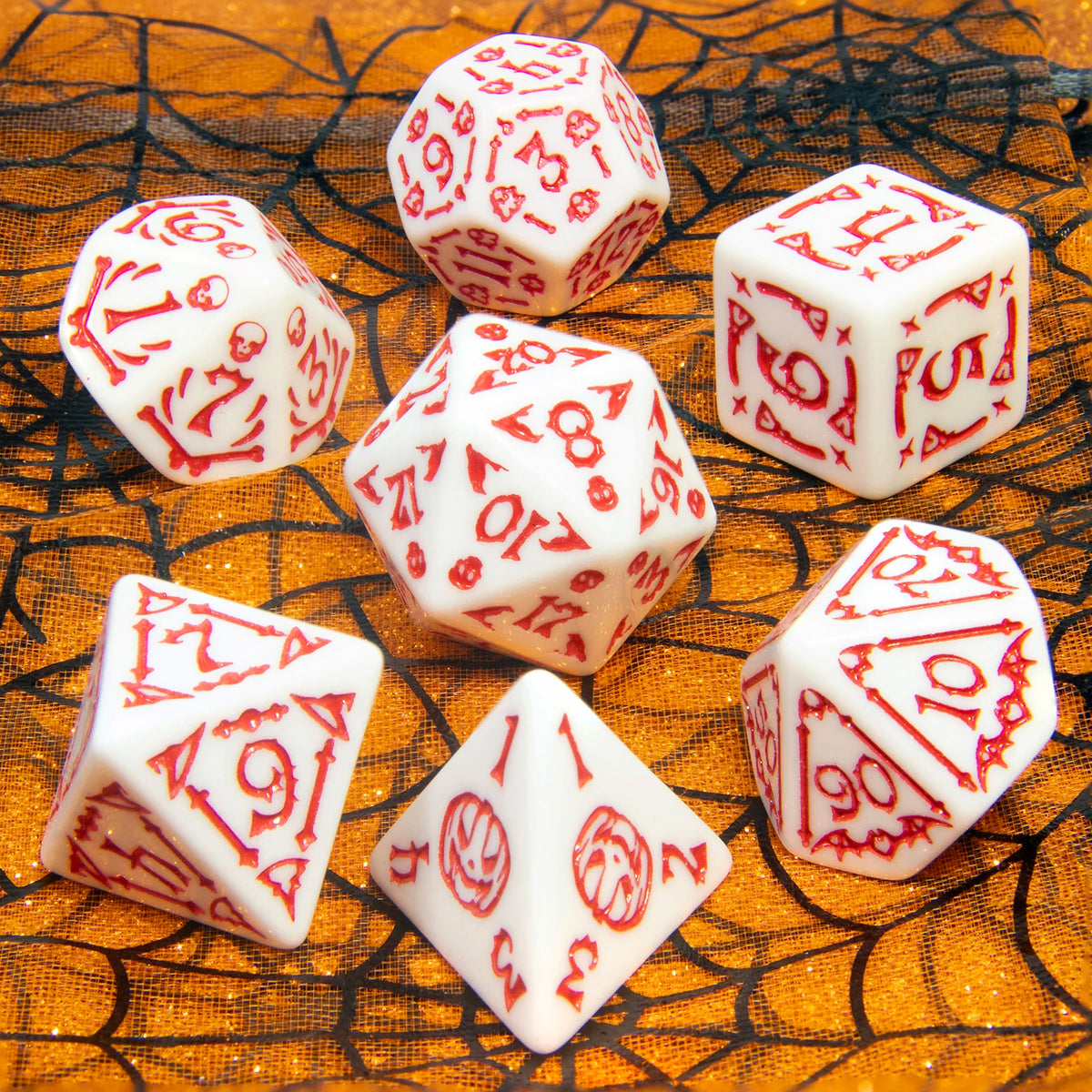 A collection of seven white and red polyhedral dice scattered on a textured orange surface.