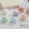 Five macaron-shaped scented soy wax candles in pastel colors including lavender, pink, green, blue, and peach.