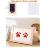 A pink photo frame and ink kit showing a wooden frame with red paw prints on white paper.