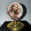 A vintage silver-framed religious ornament featuring a depiction of the Virgin Mary and the Christ Child.