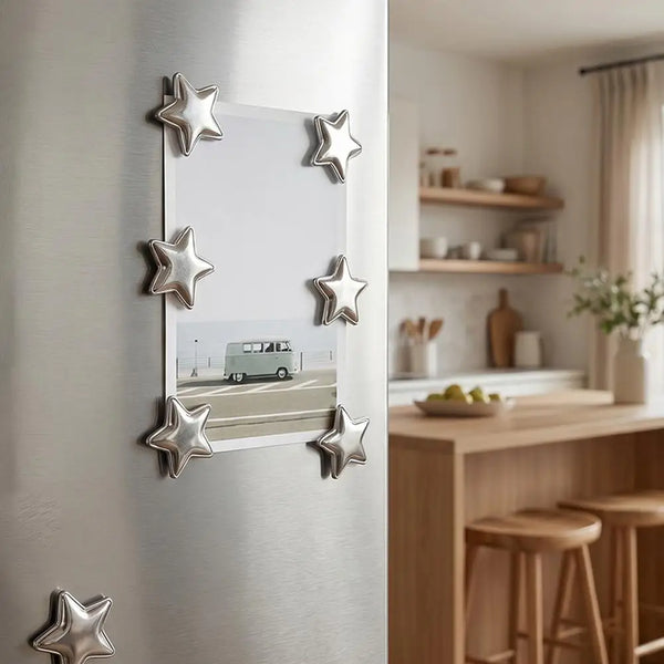 A set of ten silver star-shaped magnets displayed on a white wall, with a vintage car visible in the background.