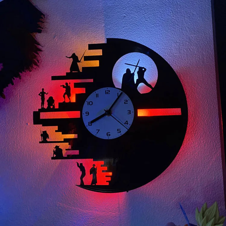 A wall clock featuring silhouettes of figures and a clock face illuminated with red and blue light.