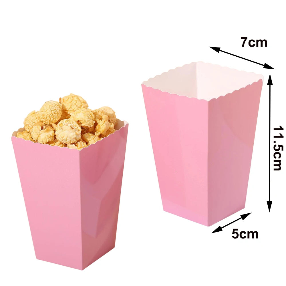 Pink disposable paper cup filled with light yellow popcorn