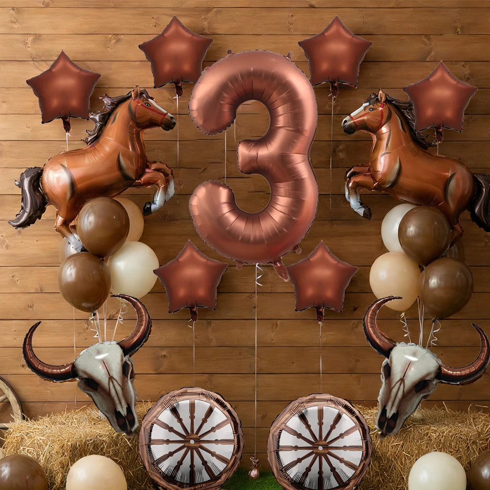 A set of bronze and gold foil balloons shaped like horses and the number three arranged against a wooden background.